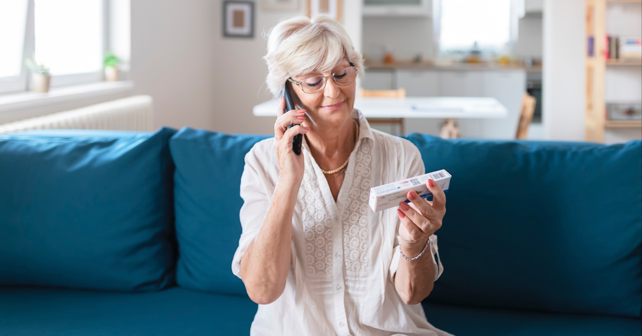 eldery patient on the phone looking at medication