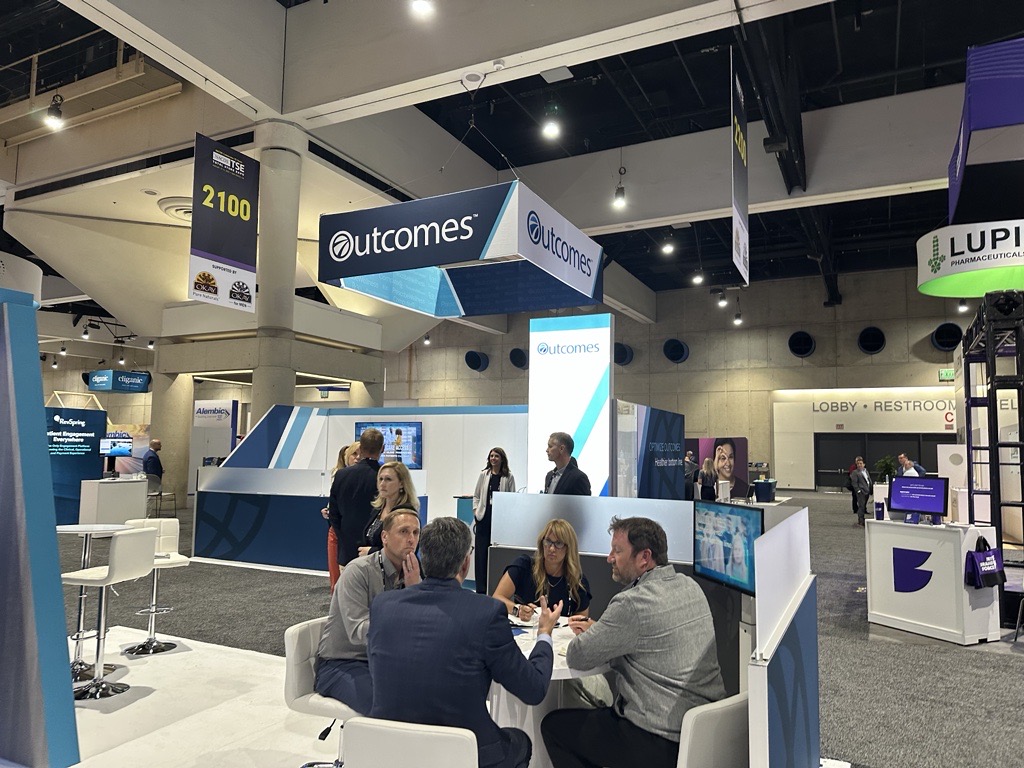 Outcomes team meeting clients in their booth at an event. 